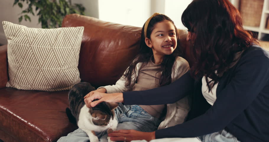 Mom, girl and cat with smile on couch, care and play with love, bonding or connection at home. People, mother and daughter in living room for pet animal, stroke and relax on sofa at family house