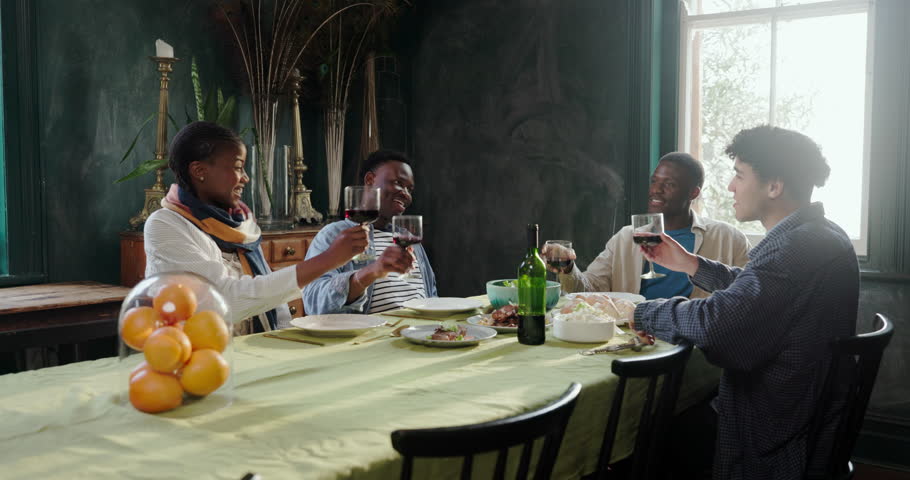 Excited, people and cheers with red wine at house for celebration, dinner party and reunion. Group, friends and toast with alcohol glass for good news, social gathering and happy hour in dining room