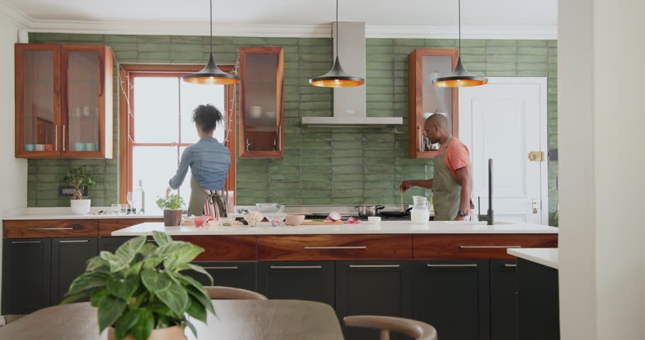 Woman in kitchen setting table with napkins, preparing for diverse family celebration, at home. preparation, dining, tableware, hospitality, festive, occasion