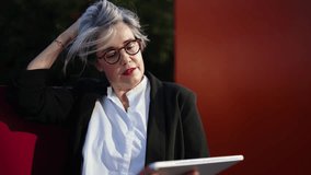 Professional woman outdoors holding tablet while on mobile phone, symbolizing multitasking, adaptability, and strong digital communication in a modern business environment - Powered by Shutterstock - Get 15% off with code: PIKWIZARD15