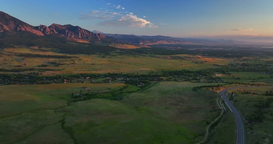 Flatirons Front Range Boulder Chautauqua Park morning sunrise aerial drone Colorado spring summer pink cloud first light on red slanted Rocky Mountains highway 36 car traffic backwards motion