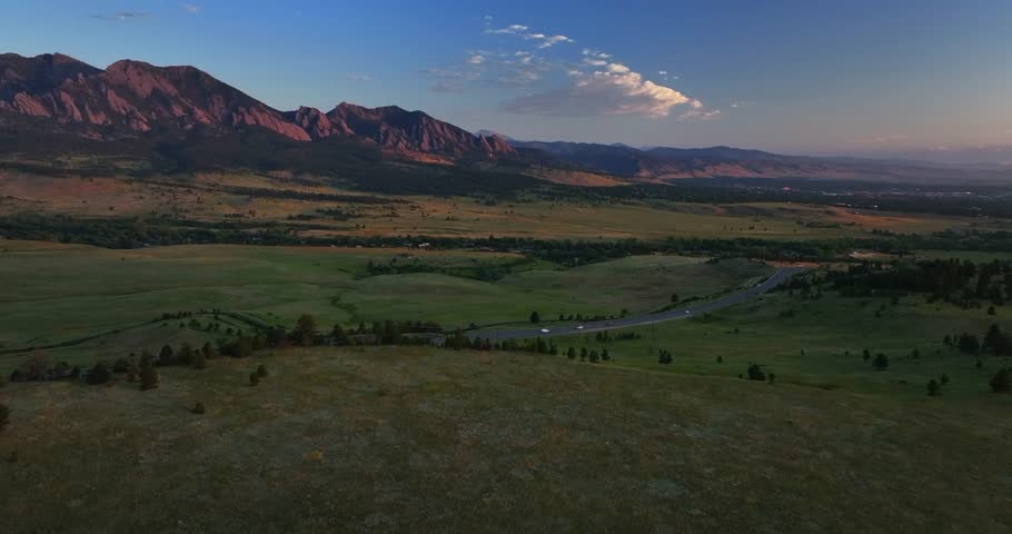 Flatirons Front Range Boulder Chautauqua Park morning sunrise aerial drone Colorado spring summer pink cloud first light on red slanted Rocky Mountains highway 36 car traffic forward pan up