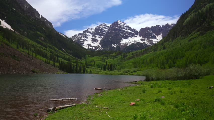 Spring summer Maroon Lake trail shoreline Maroon Bells 14er Wilderness morning sunny blue sky clouds Aspen Snowmass Colorado Elk Range Rocky Mountains White River National Forest melting snow fields