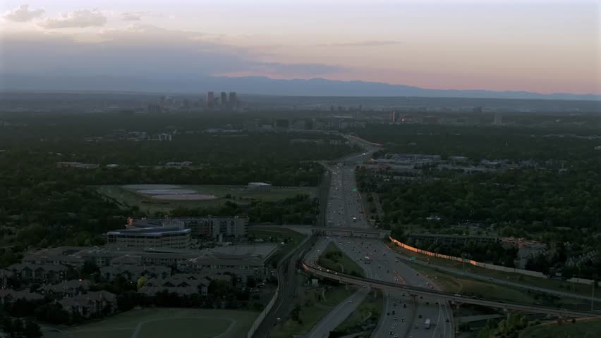 Downtown Denver i25 car truck traffic DTC Denver Tech Center Centennial cityscape aerial drone Colorado golden hour sunset clouds Lone Tree Aurora RTD lightrail Front Range Rocky Mountains down motion