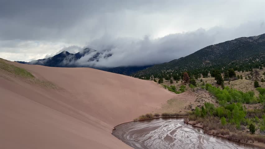 Medano Creek Great Sand Dunes National Park Sangre de Cristo range Rocky Mountains spring summer raining cloudy Colorado unique magical large amounts of sand dune hills windy landscape Crestone Needle