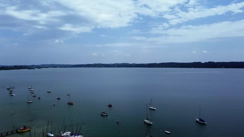 View of lake with yachts and boats under cloudy sky