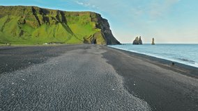 Atlantic waves rolling over Reynisfjara black sand beach Iceland. The volcanic coastline and Reynisdrangar sea stacks are filmed in cinematic 4K drone aerial perspective. - Powered by Shutterstock - Get 15% off with code: PIKWIZARD15