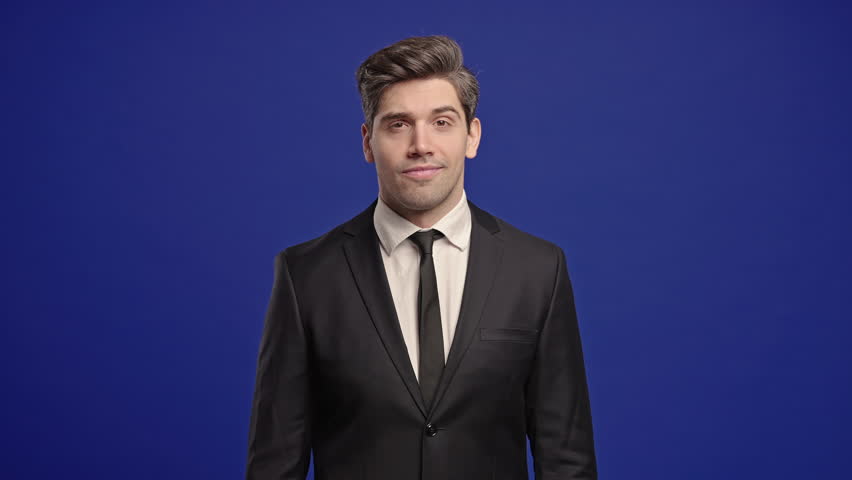 Irritated businessman in formal wear showing bla-bla-bla gesture with hands, rolling eyes on blue background. Empty promises, blah concept. Lier.