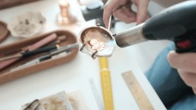 Closeup of a skilled female jeweler melting and fires a ring. Small business craftsmanship in a bright modern workshop. The detailed process of traditional  jewelry making. Artisan woman. - Powered by Shutterstock - Get 15% off with code: PIKWIZARD15