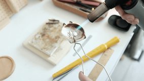 Closeup of a skilled female jeweler melting and fires a ring. Small business craftsmanship in a bright modern workshop. The detailed process of traditional  jewelry making. Artisan woman. - Powered by Shutterstock - Get 15% off with code: PIKWIZARD15