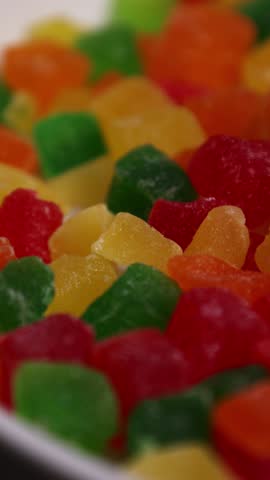 Bright colored fruit candies from dried fruits, close-up, vertical video with fruit candies.