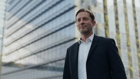 Portrait of confident company CEO records voice message on smartphone outside highrise office building. Man entrepreneur in formal clothes uses mobile phone in modern city downtown - Powered by Shutterstock - Get 15% off with code: PIKWIZARD15
