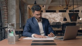 Pensive Indian business man working with papers businessman smiling in camera nodding head yes satisfied in office Arabian ethnic guy male specialist writing documents information with laptop happy - Powered by Shutterstock - Get 15% off with code: PIKWIZARD15