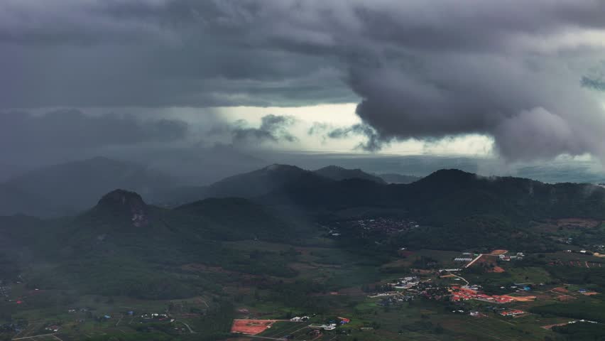 Aerial view of Monsoon clouds rolling through mountain range as storm builds over rural Asian island