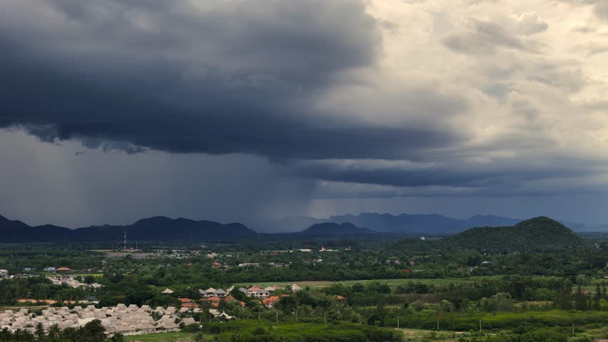 Rain clouds bringing life-giving water to rural farming landscape in tropical mountain valley