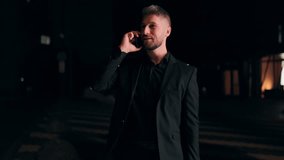 A young bearded businessman in an elegant suit makes a phone call at night while checking his wristwatch, symbolizing stress, urgency, modern lifestyle, and late work hours. - Powered by Shutterstock - Get 15% off with code: PIKWIZARD15