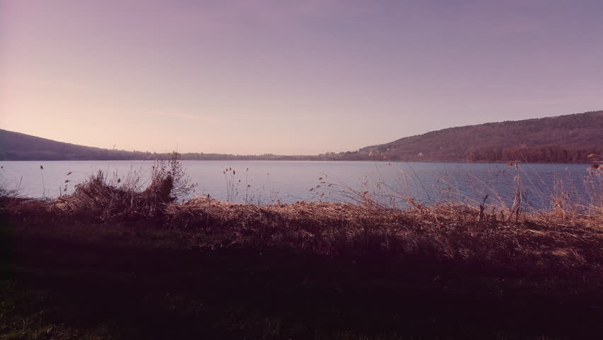 Drone Flying Over Comabbio Lake During Purple Sunrise in Lombardy Italy – Scenic Aerial Landscape