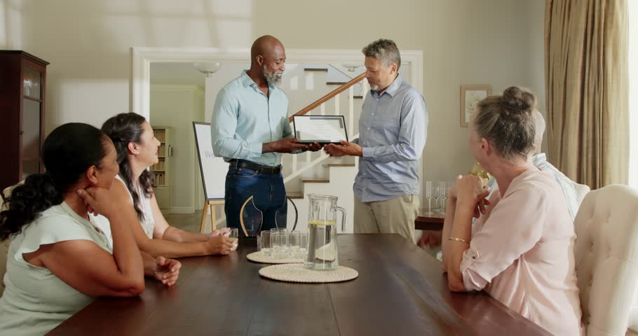 Holding award, senior man expressing gratitude to diverse friends around dining table. Celebration, achievement, friendship, reunion, party, elderly