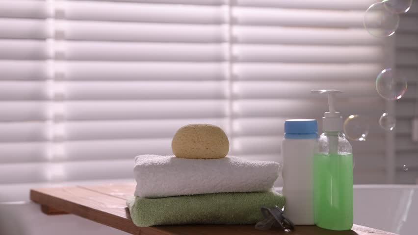 Baby accessories, bathing products and soap bubbles in bathroom, closeup