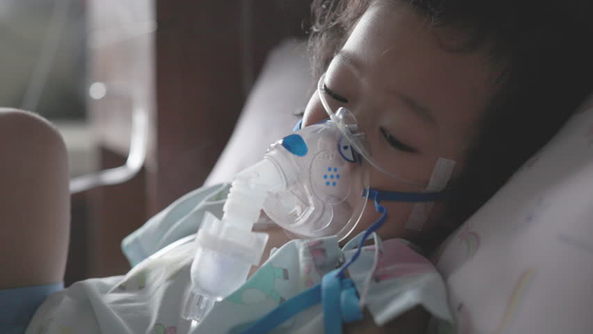 Close-up of a toddler receiving nebulizer treatment for RSV. Hospital setting highlights respiratory symptoms, pediatric illness, and emergency care.