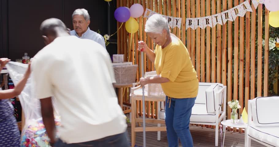 Decorating with balloons and banner, diverse family celebrating birthday with child, at home. celebration, party, festive, decoration, happiness, joy