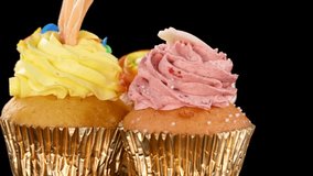 Colorful cupcakes with vibrant frosting and sprinkles rotate on black background under bright studio lighting. - Powered by Shutterstock - Get 15% off with code: PIKWIZARD15