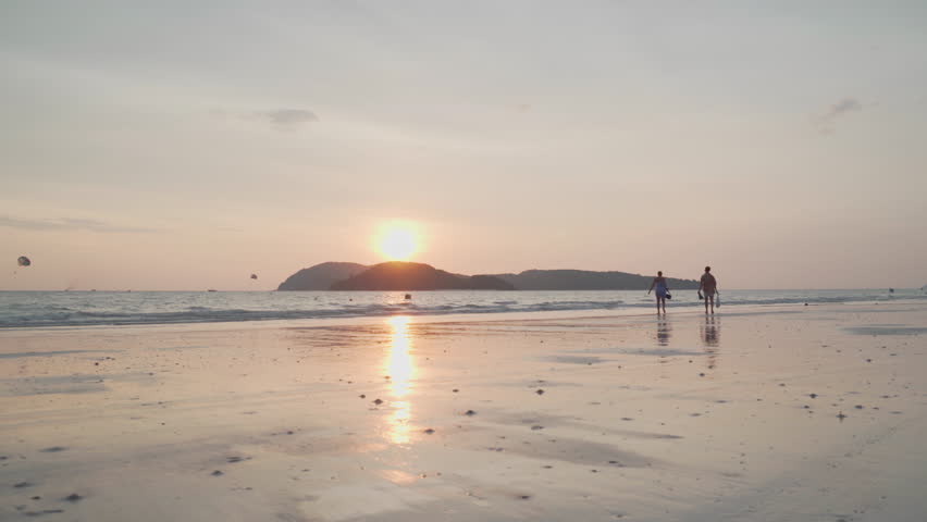 Awesome sunset view of Cenang Beach (Pantai Cenang) on Langkawi island in Malaysia. The sun is reflected in the sea and wet sand. Amazing seascape.