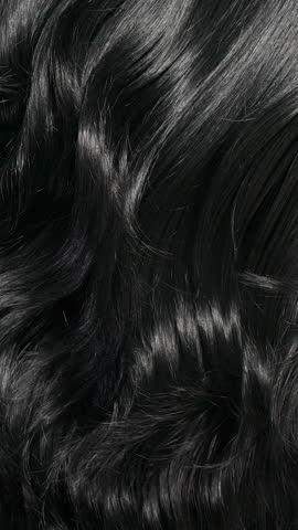 Vertical black hair texture, slow motion of female hand combing long curly hair
