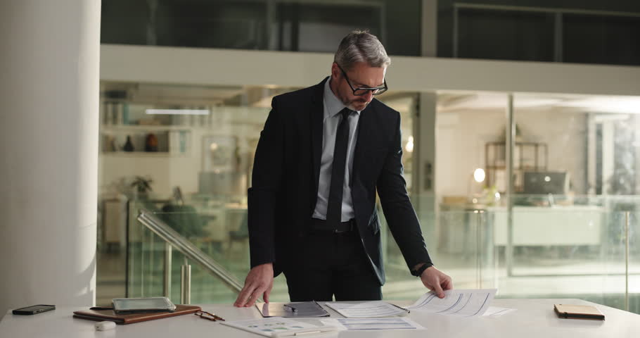 Business, man and planning with paperwork at night for case management, gather evidence or deadline. Attorney, mature man and document preparation in office for legal research, compliance or overtime