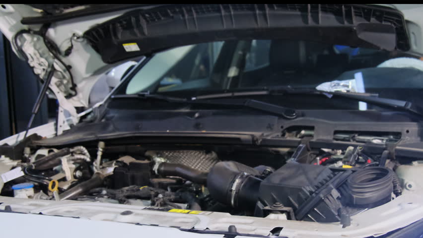 Vehicle with open hood stands in special service hall. Center allows to repair faults and perform full analysis of parts operation