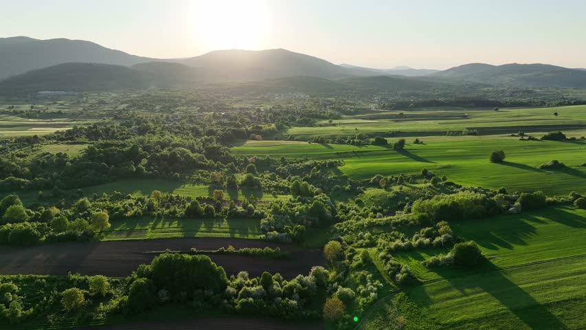 Green meadows and hills near medieval Dreznik Grad. Drone view of wide green fields and rural paths near Dreznik city. Vibrant landscape, spring growth, sense of peace typical for Croatian villages.