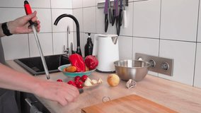 In a well-lit kitchen, a person prepares ingredients for cooking, chopping vegetables like peppers, tomatoes, and onions while arranging items neatly on the counter - Powered by Shutterstock - Get 15% off with code: PIKWIZARD15