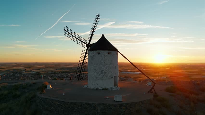 Aerial view of the historic windmills of Consuegra at sunrise, Castilla-La Mancha, Spain. Old historic windmills of Don Quixote character on the hills in morning light. Molinos de Viento de Consuegra
