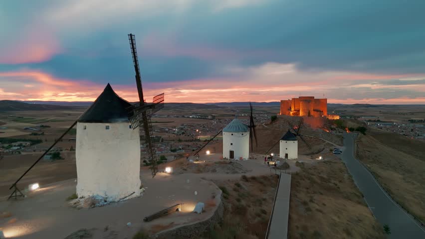 Aerial view of the historic windmills of Consuegra at night, Castilla-La Mancha, Spain. Old historic windmills of Don Quixote character on the hills at twilight. Molinos de Viento de Consuegra