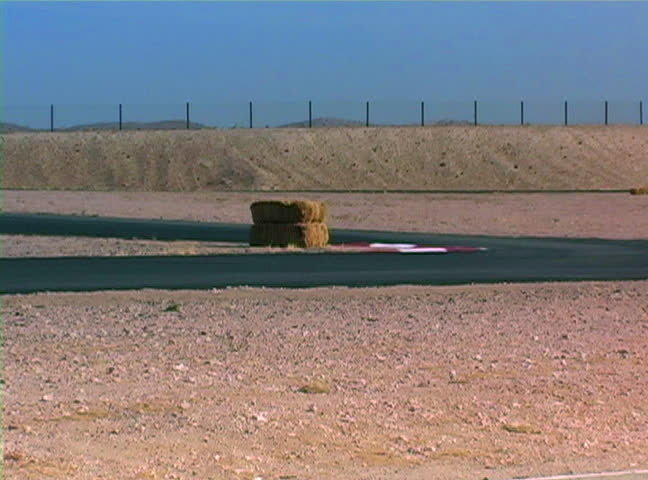 Cars race down track