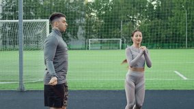 Man and woman warming up for box training at sports ground. Boxer jumping using skipping rope. Boxer woman trains with male partner outdoors. Boxer routine. Slow motion. 4K, UHD - Powered by Shutterstock - Get 15% off with code: PIKWIZARD15