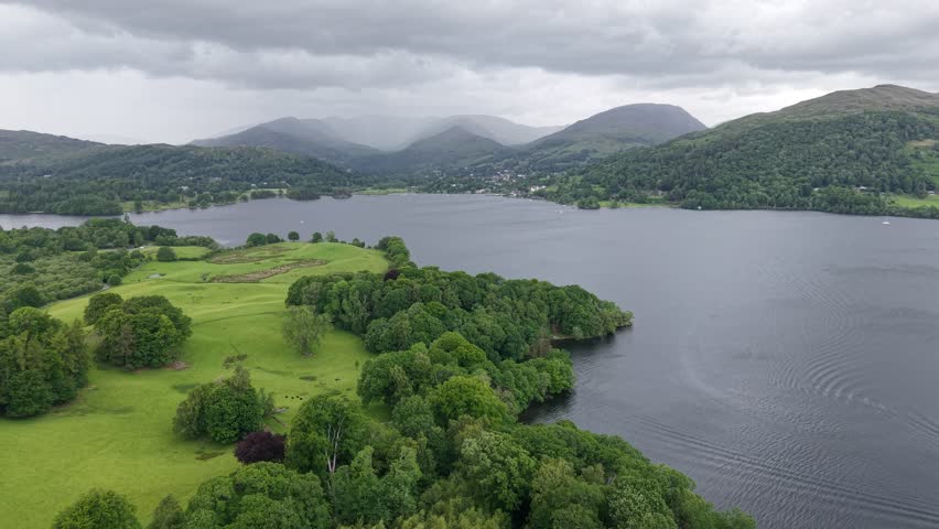 Serene landscape of a lake surrounded by lush hills and mountains in the afternoon twilight