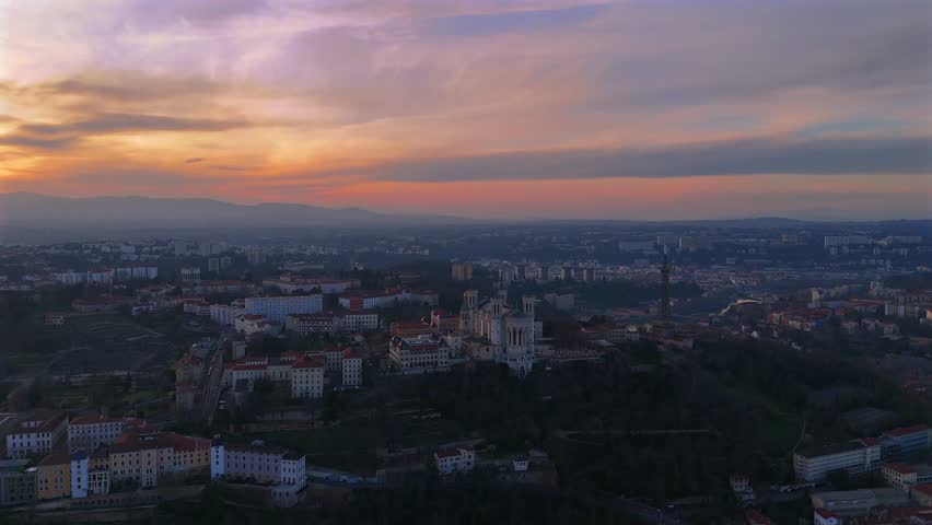 Sunset drone aerial of Fourviere Basilica and metallic tower in Lyon skyline