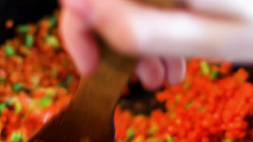 Cooking vibrant red lentils with green peppers and onions