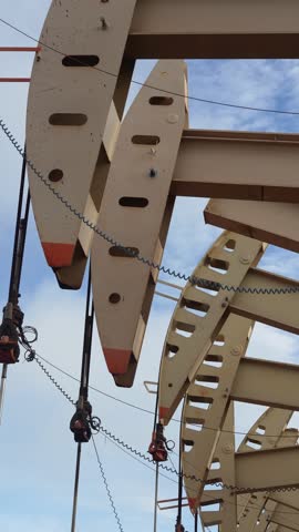 Beam pump or Donkey pump operating to recovered crude oil from the production oil well, with highlight sky background. Industrial with technology scene.