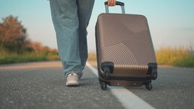 Traveler with suitcase walking along asphalt. Woman pulls luggage on road. Journey starts with walking steps of traveler. Suitcase moves with person along asphalt. Travel road with suitcase and man. - Powered by Shutterstock - Get 15% off with code: PIKWIZARD15