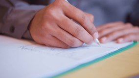 Close-up of young man's hand sketching architectural layout on white paper with ballpoint pen, focused on drawing with precise lines on clipboard, illustrating creativity, detail, and concentration - Powered by Shutterstock - Get 15% off with code: PIKWIZARD15