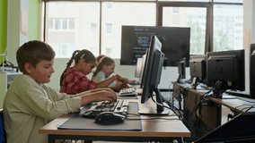 Row of youthful diligent learners of modern programming school sitting by desks in front of computer monitors at lesson and typing while carrying out individual tasks - Powered by Shutterstock - Get 15% off with code: PIKWIZARD15