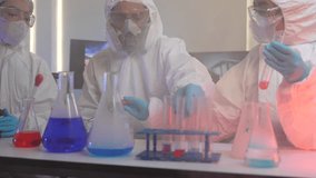 A team of scientists in full protective suits compares two different chemical samples. They are working together in a high-tech lab to find the right formula for a new cure. - Powered by Shutterstock - Get 15% off with code: PIKWIZARD15