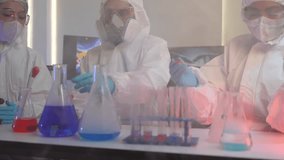 team of scientists in full protective suits compares two different chemical samples. They are working together in a high-tech lab to find the right formula for a new cure. - Powered by Shutterstock - Get 15% off with code: PIKWIZARD15