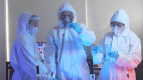 team of scientists in full protective suits compares two different chemical samples. They are working together in a high-tech lab to find the right formula for a new cure. - Powered by Shutterstock - Get 15% off with code: PIKWIZARD15