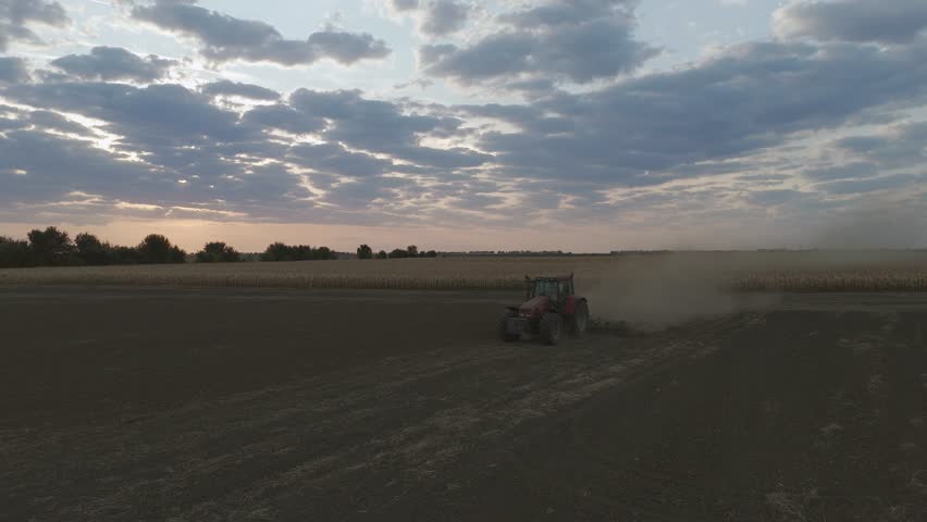 Tractor Plowing Field At Sunrise