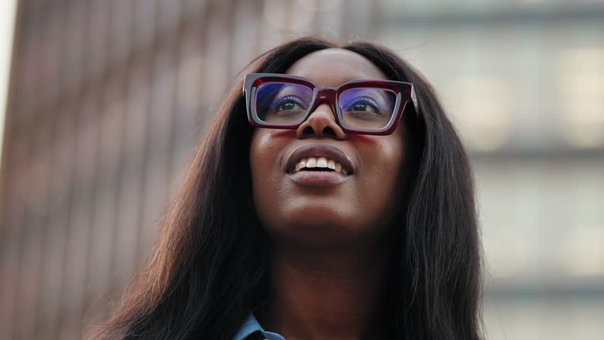 Inspired African Business Woman with glasses looking in the city with aspirations