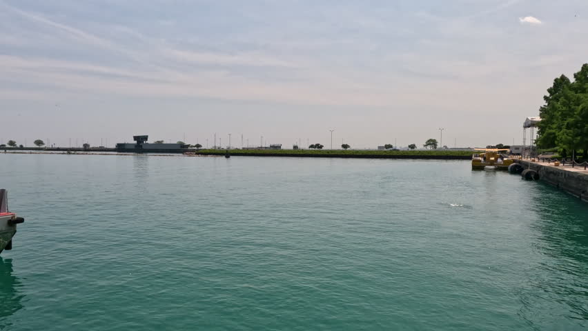 Sweeping views of the Chicago, Illinois waterfront as viewed from Navy Pier. Summer scene on the edge of Lake Michigan with boats moored along the dock.