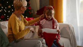 Happy grandmother and granddaughter are having fun putting on santa hats and playing with christmas decorations - Powered by Shutterstock - Get 15% off with code: PIKWIZARD15